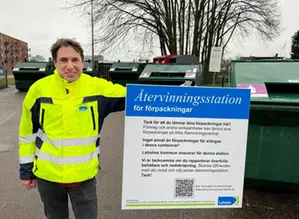Avfallsingenjör Daniel Zetreus visar ny informationsskylt på en återvinningsstation