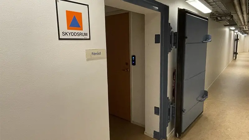 Korridor med en öppen dörr in till skyddsrum